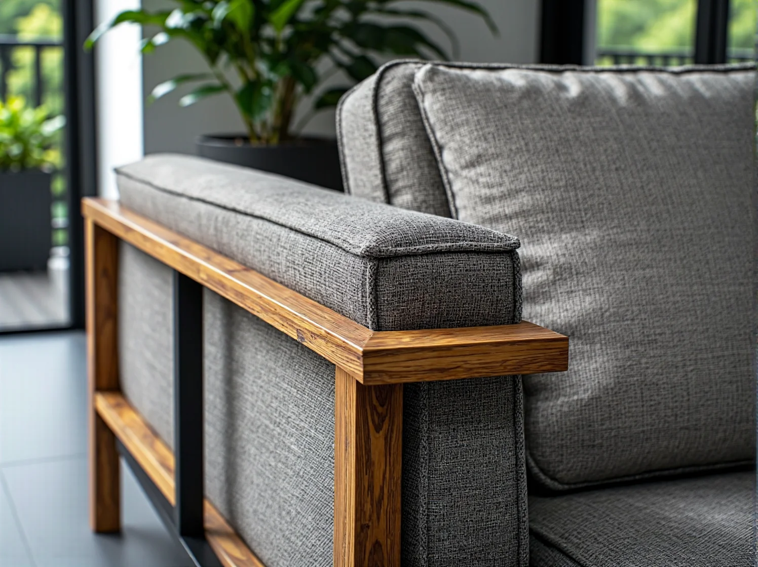 Szara sofa z drewnianym stelażem i tapicerowanymi poduszkami