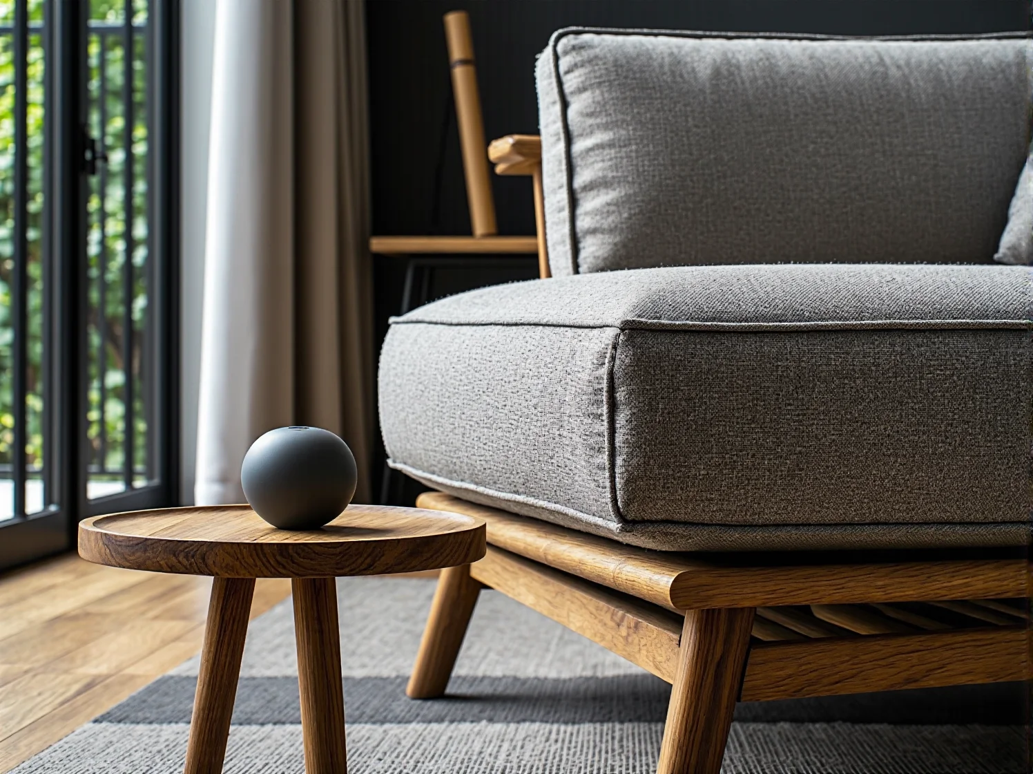 Szary fotel tapicerowany na drewnianej dębowej podstawie