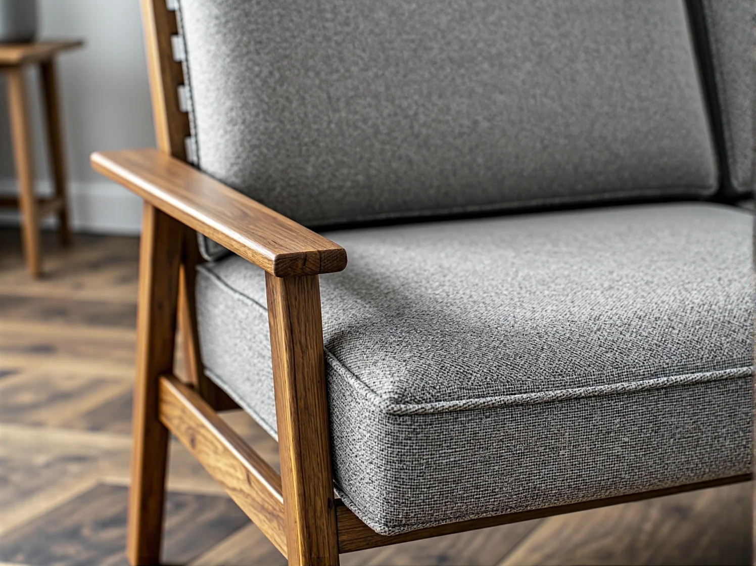 Szary fotel wypoczynkowy z drewnianymi podłokietnikami i ramą
