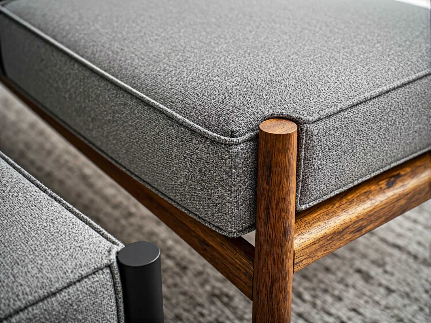 Szary tapicerowany fotel na drewnianych nogach z orzecha