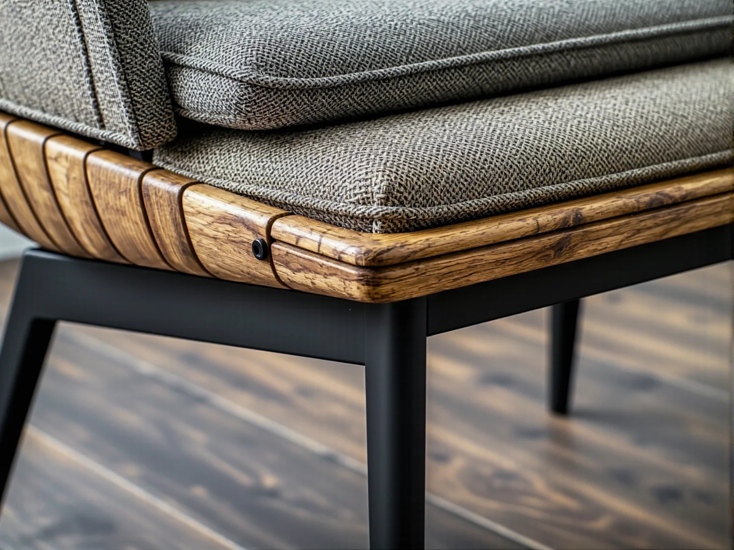 Szary fotel z drewnianą ramą i czarnymi metalowymi nogami