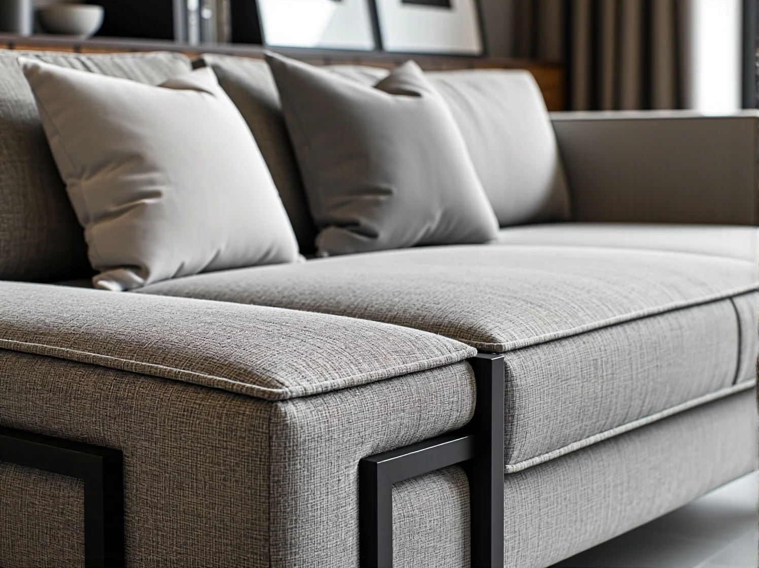 Szara sofa tapicerowana z poduszkami i metalowym stelażem